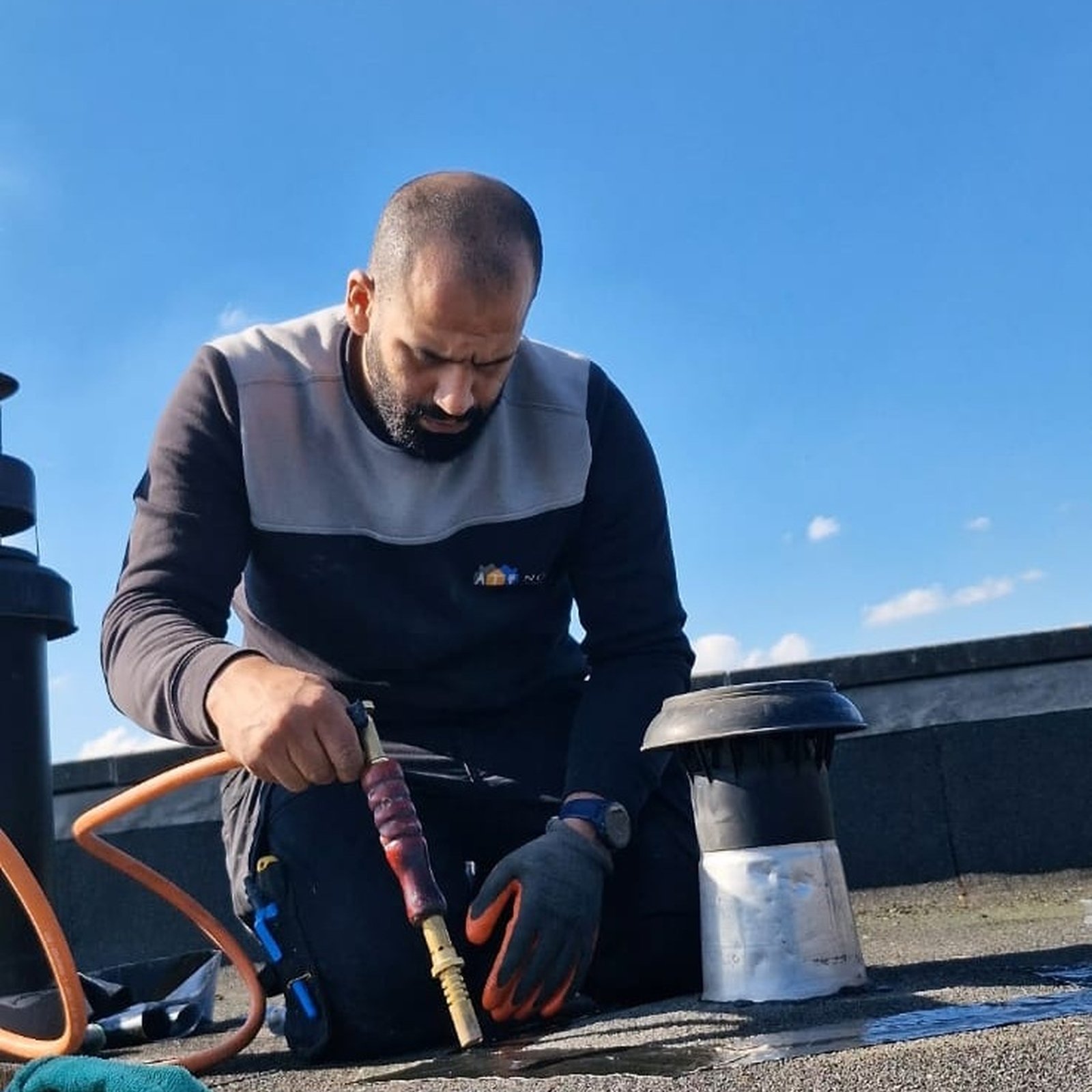 Dakbedekking branden rond de dakdoorvoer | Nour Klusbedrijf Vakman brandt bitumen dakbedekking rond een dakdoorvoer op een plat dak